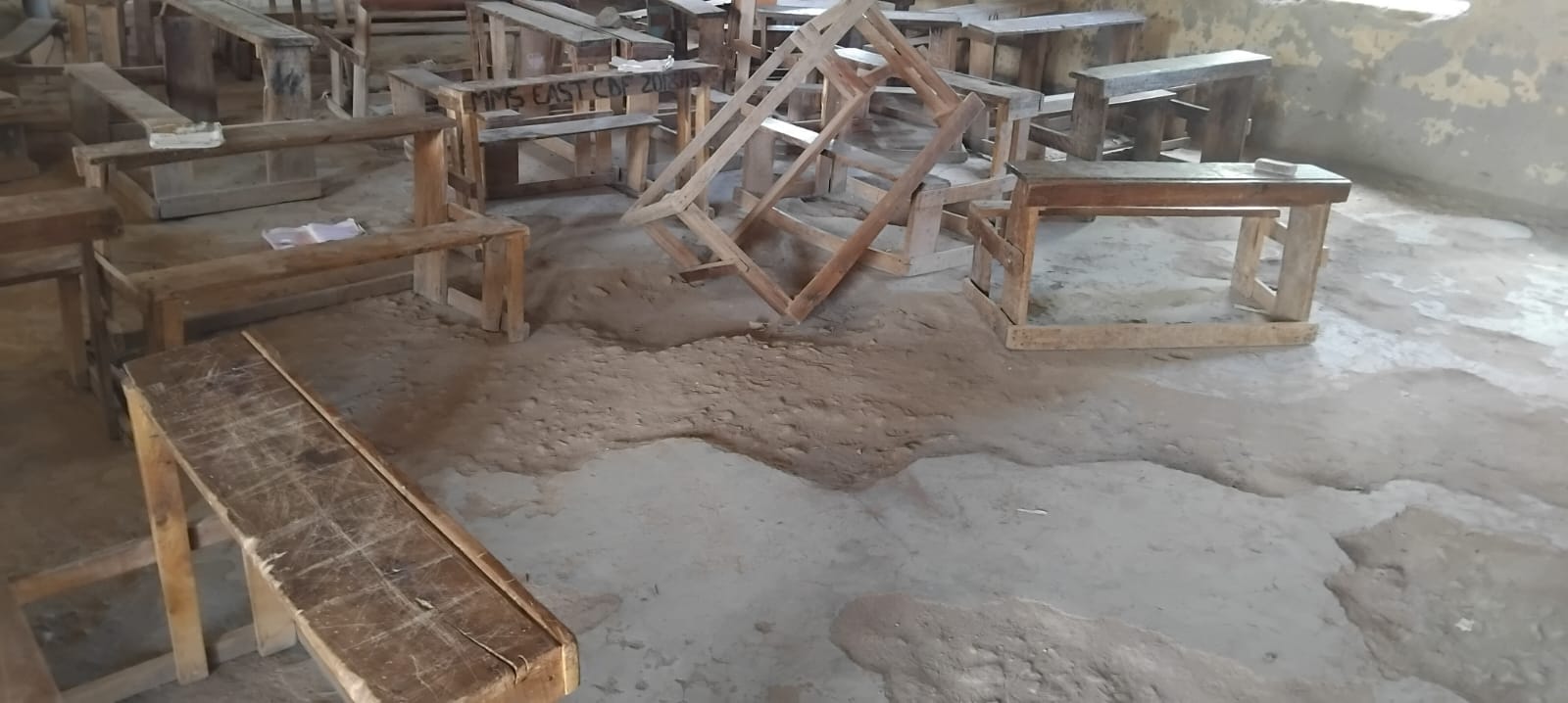 A classroom at Eshisenye Primary School with the concrete floor broken down to bare soil