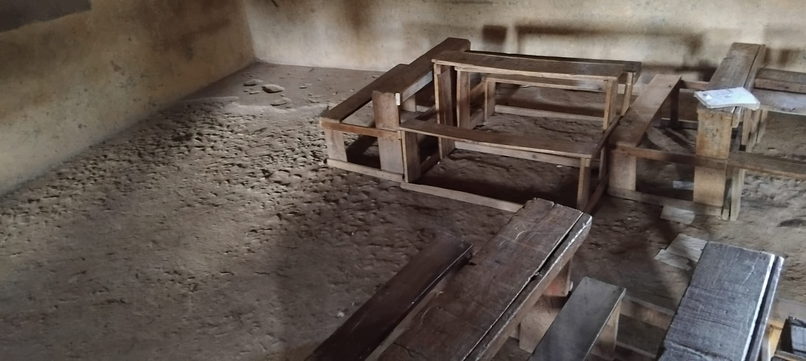 Loose earth and rubble covering a classroom floor at Eshisenye Primary School